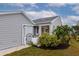 Side view of a gray house with well-manicured landscaping and a walkway at 1229 Spoonbill Landings Cir, Bradenton, FL 34209