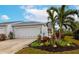 Gray house with attached garage, nicely landscaped front yard, and palm trees at 1229 Spoonbill Landings Cir, Bradenton, FL 34209