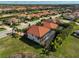An aerial view shows homes with red roofs and screened lanais, nestled within a lush, green landscape at 13408 Swiftwater Way, Bradenton, FL 34211