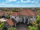 An aerial view of the stunning property highlights its stucco exterior, tile roof, and meticulously maintained landscaping at 13408 Swiftwater Way, Bradenton, FL 34211
