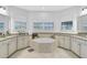 Bright bathroom featuring a soaking tub, tile floor, granite counters, and white cabinets at 13408 Swiftwater Way, Bradenton, FL 34211