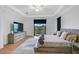 Light bedroom boasts a dresser, TV, a large window, and a balcony at 13408 Swiftwater Way, Bradenton, FL 34211