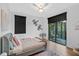 Bedroom with a ceiling fan, hardwood floors, and an adjacent balcony with furniture at 13408 Swiftwater Way, Bradenton, FL 34211