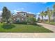 Beautifully landscaped two-story home features a stone facade and a paver driveway, complemented by lush landscaping at 13408 Swiftwater Way, Bradenton, FL 34211
