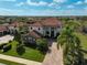 Stunning two-story home boasts a tile roof, beautiful columns, brick driveway, and lush landscaping at 13408 Swiftwater Way, Bradenton, FL 34211