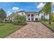 Elegant two-story home with lush landscaping, brick driveway, and stately pillars at 13408 Swiftwater Way, Bradenton, FL 34211