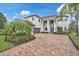 Stately home with brick drive, lush landscaping, and a striking blue entry door at 13408 Swiftwater Way, Bradenton, FL 34211