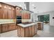 Open kitchen showcases custom wood cabinets, a cooktop island, and stainless steel appliances at 13408 Swiftwater Way, Bradenton, FL 34211