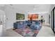 Bright living room featuring a large blue sectional couch and open kitchen view at 13408 Swiftwater Way, Bradenton, FL 34211