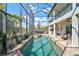 A screened in pool with a sun shelf, spa, outdoor grill, and seating at 13408 Swiftwater Way, Bradenton, FL 34211