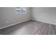 Bright bedroom with gray vinyl flooring and a view from the window at 15026 Dania Ave, Port Charlotte, FL 33953