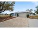 Front view of a light blue house with a two-car garage at 15026 Dania Ave, Port Charlotte, FL 33953