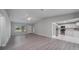 Open living room and kitchen with gray vinyl flooring at 15026 Dania Ave, Port Charlotte, FL 33953