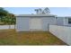 Gray storage shed in backyard with roll-up door at 15026 Dania Ave, Port Charlotte, FL 33953