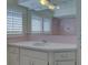 Bathroom with pink tile, vanity, and large mirror at 1610 Cypress Point Ct, Venice, FL 34293