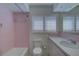 Bathroom with pink tile, shower, and vanity at 1610 Cypress Point Ct, Venice, FL 34293