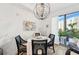 Bright dining area with round table and four chairs, features a modern chandelier and large window at 1703 N Tamiami Trl # 209, Sarasota, FL 34234