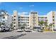 Modern building exterior with ample parking and tropical landscaping at 1703 N Tamiami Trl # 209, Sarasota, FL 34234