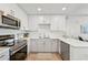 Modern kitchen with white cabinets, stainless steel appliances, and quartz countertops at 1703 N Tamiami Trl # 209, Sarasota, FL 34234