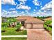 Luxury home with a tile roof, landscaped yard, and brick driveway at 20686 Valprato Ct, Venice, FL 34293