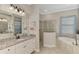 Bright bathroom features double sinks, granite countertops, a soaking tub, and tiled shower at 20686 Valprato Ct, Venice, FL 34293