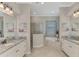 Bright bathroom boasts double sinks, granite countertops, a soaking tub, and tiled walk-in shower at 20686 Valprato Ct, Venice, FL 34293