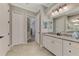 Well-lit bathroom featuring a tiled floor, white vanity with granite countertops, and access to storage at 20686 Valprato Ct, Venice, FL 34293