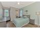 Charming bedroom features wood-look tile flooring, a ceiling fan, and coastal decor at 20686 Valprato Ct, Venice, FL 34293