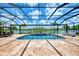 Screened-in pool with lake view, tile flooring, and outdoor seating at 20686 Valprato Ct, Venice, FL 34293