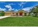Single-story home with a red door and nicely landscaped lawn at 2534 Stagnaro Rd, North Port, FL 34287