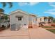 Gray mobile home with a small porch and air conditioning unit at 283 Bainbridge Dr, Nokomis, FL 34275