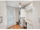 Bright laundry room with stacked washer and dryer, and built in cabinets at 283 Bainbridge Dr, Nokomis, FL 34275
