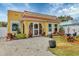 Charming yellow house with a tile roof, landscaping, and a gravel driveway at 305 Pameto Rd, Nokomis, FL 34275