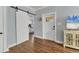 Bright hallway with hardwood floors, a barn door, and white trim at 305 Pameto Rd, Nokomis, FL 34275