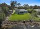 An aerial view of the backyard showcases a well-maintained lawn and screened-in lanai that backs up to a canal at 3151 Johannesberg Rd, North Port, FL 34288