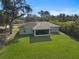 An aerial view showcases a lush backyard featuring a well-maintained lawn, a screened lanai in a quiet neighborhood at 3151 Johannesberg Rd, North Port, FL 34288