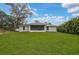 Expansive backyard of the home, featuring lush green lawn and screened-in lanai, ideal for outdoor enjoyment at 3151 Johannesberg Rd, North Port, FL 34288