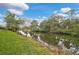 A lush green yard slopes gently down to a peaceful canal, complementing the surrounding natural landscape at 3151 Johannesberg Rd, North Port, FL 34288
