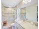 Bright bathroom featuring marble countertop vanity, tiled shower with glass door, and neutral color palette at 3151 Johannesberg Rd, North Port, FL 34288