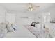 Bright bedroom with white walls, ceiling fan, a chair, and an ensuite bathroom at 3151 Johannesberg Rd, North Port, FL 34288