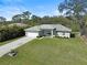 Aerial front view of a charming one-story home with a two-car garage, well-manicured lawn, and a canal in the back at 3151 Johannesberg Rd, North Port, FL 34288