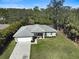 Aerial front view of a charming one-story home with a two-car garage, well-manicured lawn, and a canal in the back at 3151 Johannesberg Rd, North Port, FL 34288