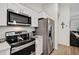 Bright kitchen with stainless steel appliances including a range, microwave and refrigerator at 3151 Johannesberg Rd, North Port, FL 34288