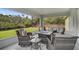 The covered patio is furnished for lounging, offering scenic views of the lush backyard and tranquil waterway at 3151 Johannesberg Rd, North Port, FL 34288