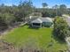 Aerial view of a home's rear featuring a screened lanai and a spacious, well-maintained backyard at 3151 Johannesberg Rd, North Port, FL 34288