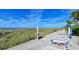 Beachfront view with lounge chairs and shower at 3810 Gulf Of Mexico Dr # F302, Longboat Key, FL 34228