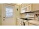 Bright kitchen with white appliances and wood cabinets at 3810 Gulf Of Mexico Dr # F302, Longboat Key, FL 34228