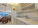 Kitchen with white cabinets, sink, and a view into the dining area at 3810 Gulf Of Mexico Dr # F302, Longboat Key, FL 34228