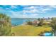 Scenic waterfront view with lush lawn, gazebo, and dock at 3810 Gulf Of Mexico Dr # F302, Longboat Key, FL 34228