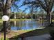Tranquil pond with fountain, landscaping, and condo building in background at 425 30Th W Ave # C212, Bradenton, FL 34205